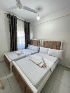 Dos camas en un dormitorio con toallas. en Comfort Home Two Bedroom Buxton point Mombasa, en Mombasa