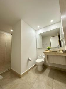 a bathroom with a toilet and a sink and a mirror at Hotel Tayrona del Mar in Santa Marta