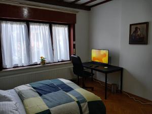 ein Schlafzimmer mit einem Bett und einem Schreibtisch mit Computer in der Unterkunft Assenaar in Asse