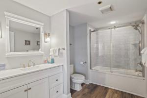 a white bathroom with a shower and a toilet at 215 Water Street Inn in Boyne City +14 photos