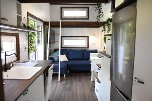 グジボボにあるDomek -Tiny House Resort Marinoの小さな家の中のキッチン(青いソファ付)