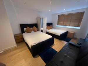 een kamer met twee bedden en een bank erin bij The O2 Arena ExCel Canary Wharf London in Londen