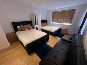 een woonkamer met twee bedden en een bank bij The O2 Arena ExCel Canary Wharf London in Londen