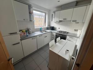 een witte keuken met witte kasten en een raam bij The O2 Arena ExCel Canary Wharf London in Londen
