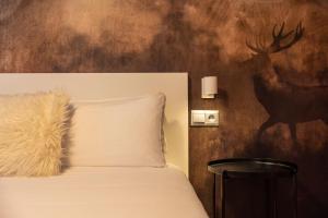 a bed with a white pillow and a painting of a deer at TOP Vistas Al Valle Arinsal - 6PAX - A Pie De Pistas & ESQUÍ - Free Parking l by BonesVacances in Arinsal