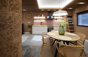 a kitchen with a table with chairs and a vase with flowers at Arrokarenea in Valcarlos