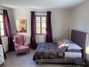 una camera da letto con un letto, una sedia e una finestra di Maison de village à Gassin a Gassin
