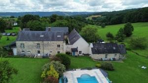 an aerial view of a large stone house with a swimming pool at Domaine de Cantelou in Clécy