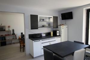 a kitchen with a table and a white refrigerator at Sous La Treille in Saze +29 photos