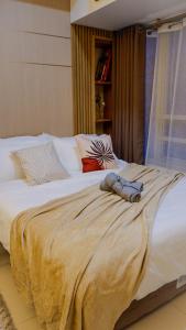 a large white bed with a blanket on it at New Cozy Condo in Eastwood in Manila +15 photos