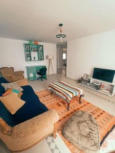 a living room with two couches and a flat screen tv at Villa avec piscine privée in Potinville