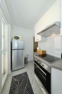 a kitchen with a stainless steel refrigerator at Apartment Zamalin SeaView in Tribunj +17 photos