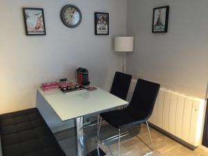 a dining room table with chairs and a clock on the wall at Studio Urban Chic Annecy in Annecy +19 photos