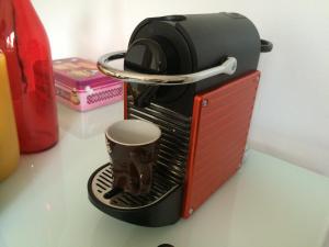 une cafetière assise sur un comptoir avec une tasse dans l'établissement Studio Urban Chic Annecy, à Annecy