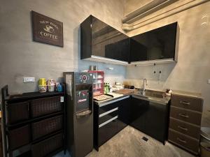 a small kitchen with a refrigerator and a sink at Bear&Best Homestay in Yuli