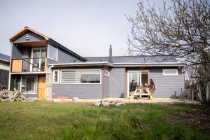 two people sitting at a table outside of a house at Patagonia Mai Casa Boutique in Puerto Natales