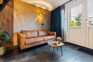 a living room with a leather couch and a table at Loft 29 in Zandvoort
