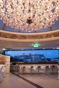 a large chandelier in a hotel lobby with a bar at The Athenian Callirhoe Exclusive Hotel in Athens