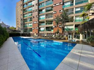 una grande piscina blu di fronte a un edificio di Praça Madá a San Paolo
