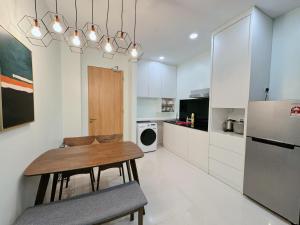 クチンにあるKuching Cozy Comfort 01 - Riverine Diamond Kuching 4 Paxの木製のテーブルと冷蔵庫のあるキッチン