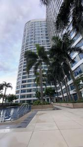 a tall building with palm trees in front of it at New Cozy Condo in Eastwood in Manila