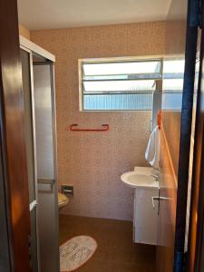 a bathroom with a sink and a toilet and a window at Pousada Matriz 2 in Ouro Fino