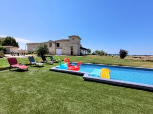 a backyard with a swimming pool with chairs and a house at La Colline Gersoise-Piscine-Sauna in La Sauvetat