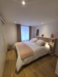 a bedroom with a large bed and a window at Maison de bourg bretonne in Baulon
