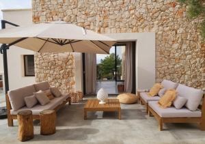 a living room with two couches and an umbrella at Villa Boho in Salignano