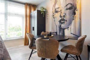 a dining room with a table and chairs at De Schelp 58 in Zandvoort