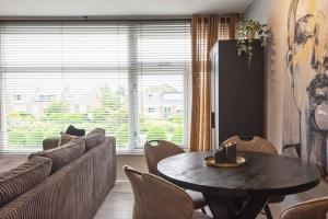a living room with a table and a couch at De Schelp 58 in Zandvoort