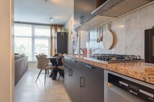 a kitchen with a stove top oven next to a table at De Schelp 58 in Zandvoort +38 photos