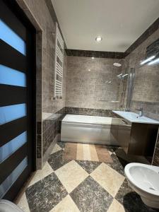 a bathroom with a tub and a toilet and a sink at Style Aparts in Chişinău