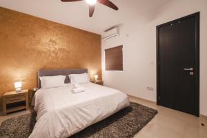 una camera da letto con un letto bianco e una porta nera di Blossom Bliss apartment a Msida
