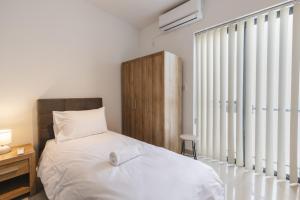 a bedroom with a bed and a large window at Blossom Bliss apartment in Msida