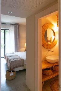 a bedroom with a bed and a sink and a mirror at Villa Boho in Salignano