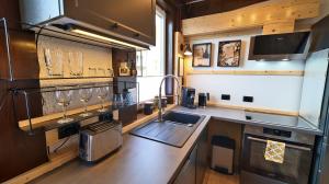 a kitchen with a sink and a counter with wine glasses at Yellow Lounge Schwarzwald - mit Veranda in Winzeln