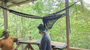 two men standing in a porch with a hammock at Landscape-Cabaña Summer-Full Equipada in La Cruz
