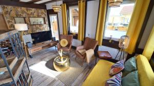 a living room with a couch and a tv at Yellow Lounge Schwarzwald - mit Veranda in Winzeln +17 photos