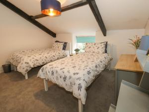 a bedroom with two beds and a window at Half Pint Cottage in Beaminster