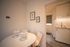 una cocina con una mesa blanca con dos cestas. en Apartment Zandster, en Zandvoort