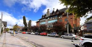 eine Straße mit Autos, die an der Seite eines Gebäudes geparkt sind in der Unterkunft VV Suítes - Apto Rua Coberta in Gramado