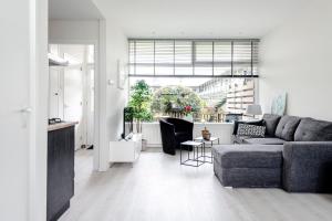 een woonkamer met een bank en een tafel bij Sea Shell apartment in Zandvoort