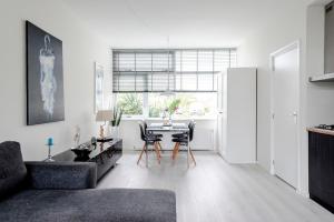 een woonkamer met een tafel en stoelen bij Sea Shell apartment in Zandvoort