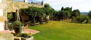 an outdoor patio with an umbrella and a yard at La Masia Costa Brava -Adults Only in Garrigás