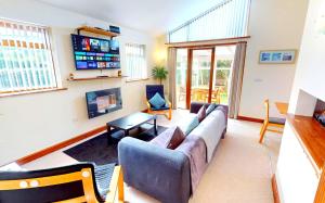 a living room with a couch and a tv at CROYDE DUNE LODGE 3 Bedrooms in Croyde