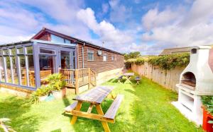 a backyard with a picnic table and a house at CROYDE DUNE LODGE 3 Bedrooms in Croyde