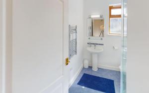 a white bathroom with a sink and a mirror at CROYDE DUNE LODGE 3 Bedrooms in Croyde +16 photos