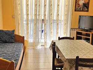 a living room with a table and a television at Tiziana in Giardini Naxos
