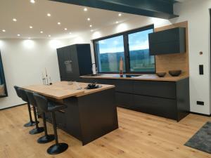 a kitchen with a large island with a wooden counter top at Lifestyle Cube House Appartment 3 in Moosbach